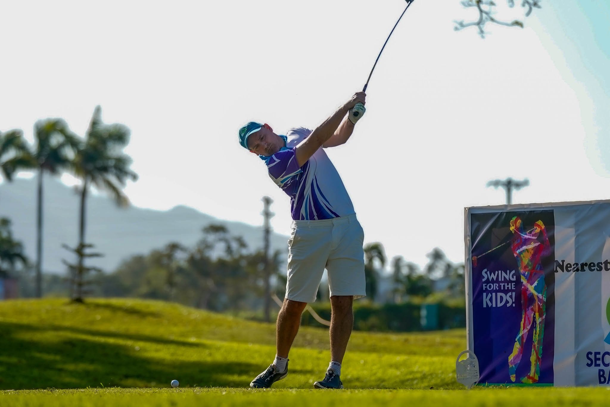 Golfer teeing off with SFTK banner