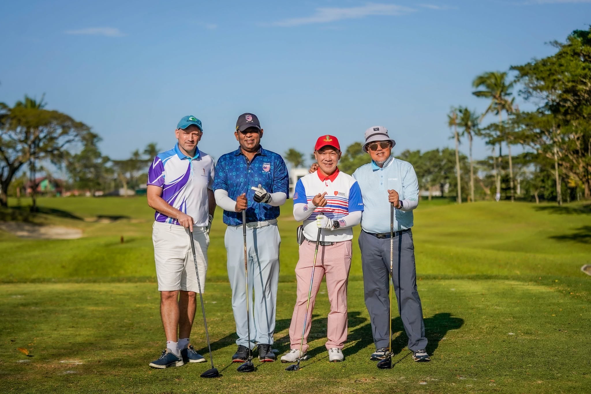 Four golfers posing on the fairway